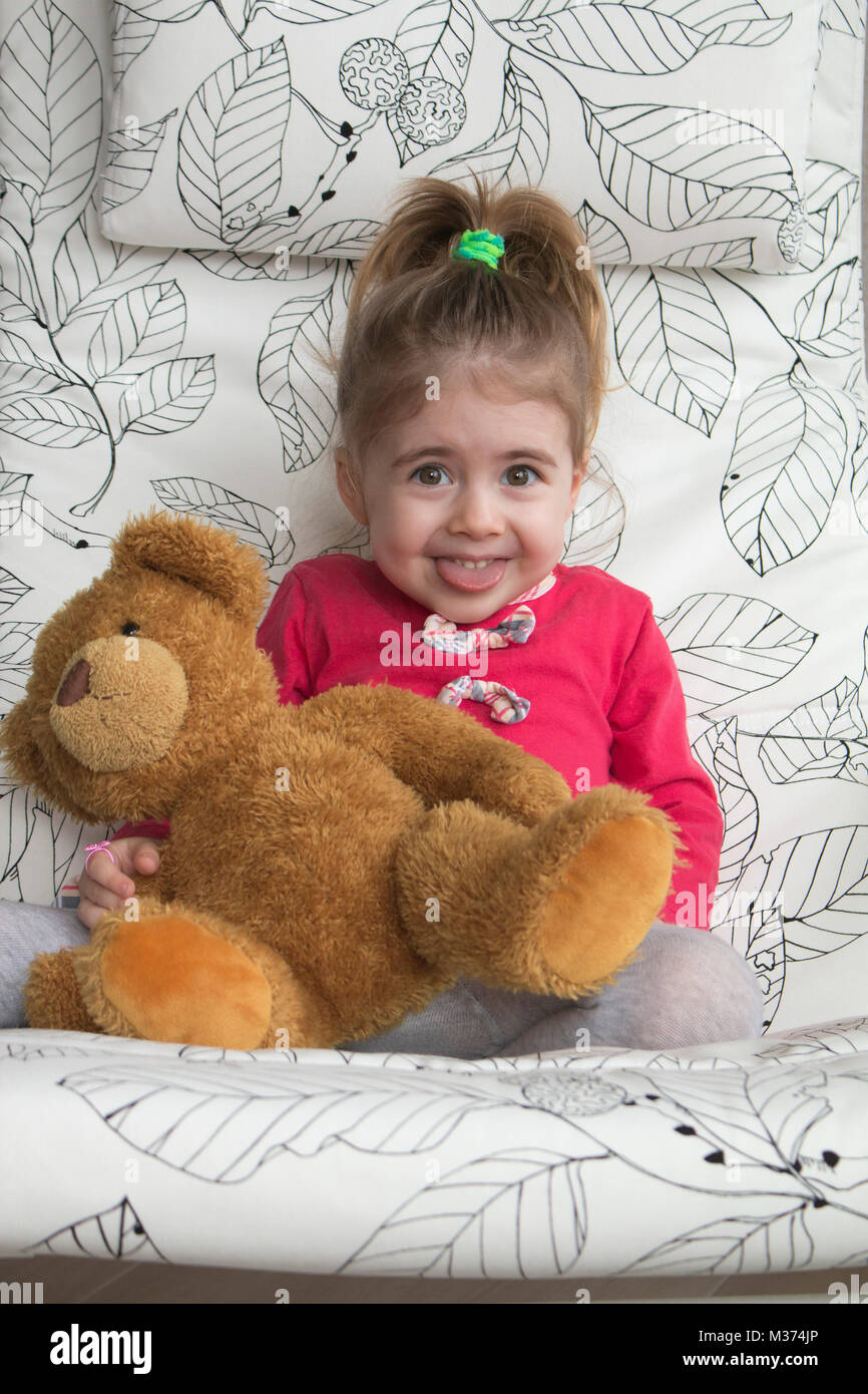 Clouse-up portrait of smiling little girl making funny grimace et gestes à l'appareil photo. Banque D'Images