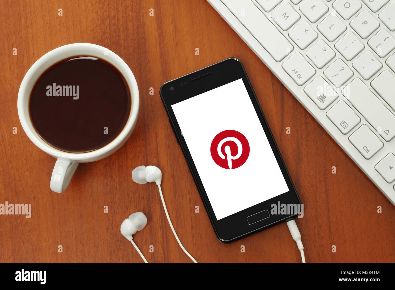 Kiev, Ukraine - 8 août 2017 : Cup Coffee et smart phone avec logo Pinterest sur son écran sur fond de bois Banque D'Images