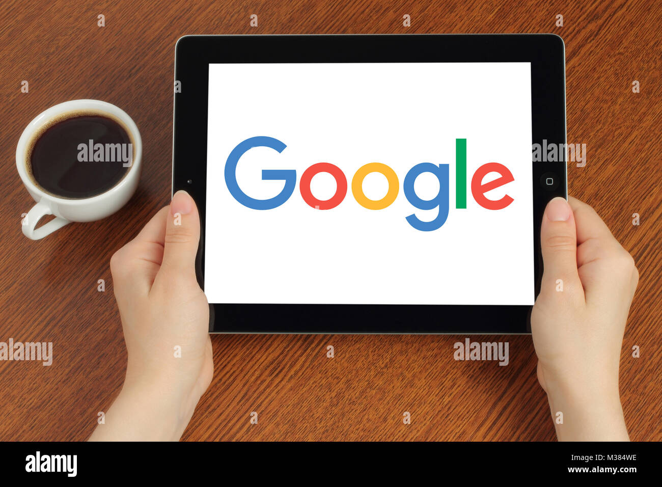 Kiev, Ukraine - 8 août 2017 : Mains maintient iPad avec logo Google sur fond de bois Banque D'Images