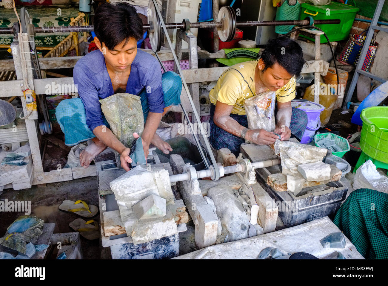 Les travailleurs sont des pierres de jade précieux de coupe en petits morceaux dans le marché de jade Banque D'Images