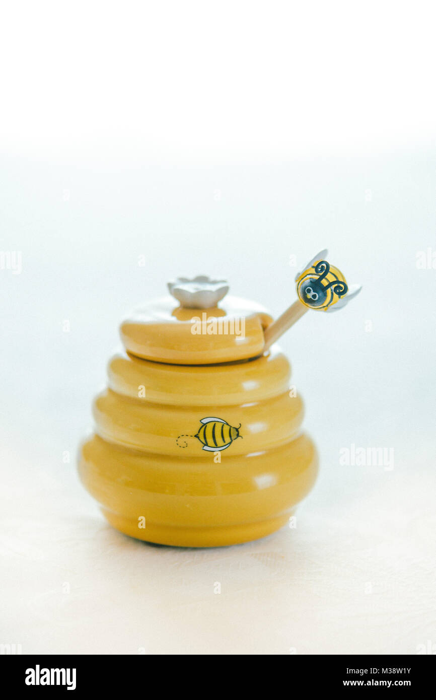 Pot de miel sur fond blanc Banque D'Images