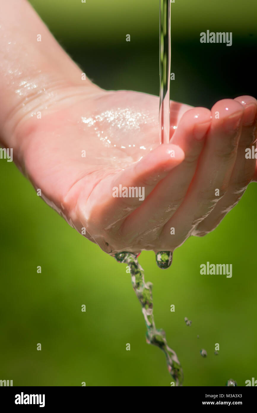 L'eau du robinet qui coule sur le bras, l'eau coule sur la main.  L'écoulement de l'eau du robinet dans le parc. , La désinfection, liquide,  transparent, poignet Photo Stock - Alamy