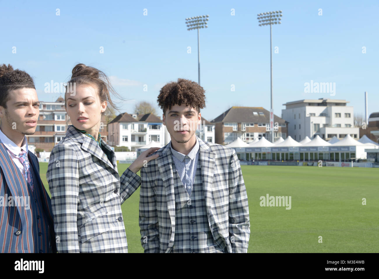 Bien habillé deux beau gars au teint foncé sont un terrain de Cricket . avec une belle jeune fille bien habillée. Ils portent des costumes sur mesure Banque D'Images