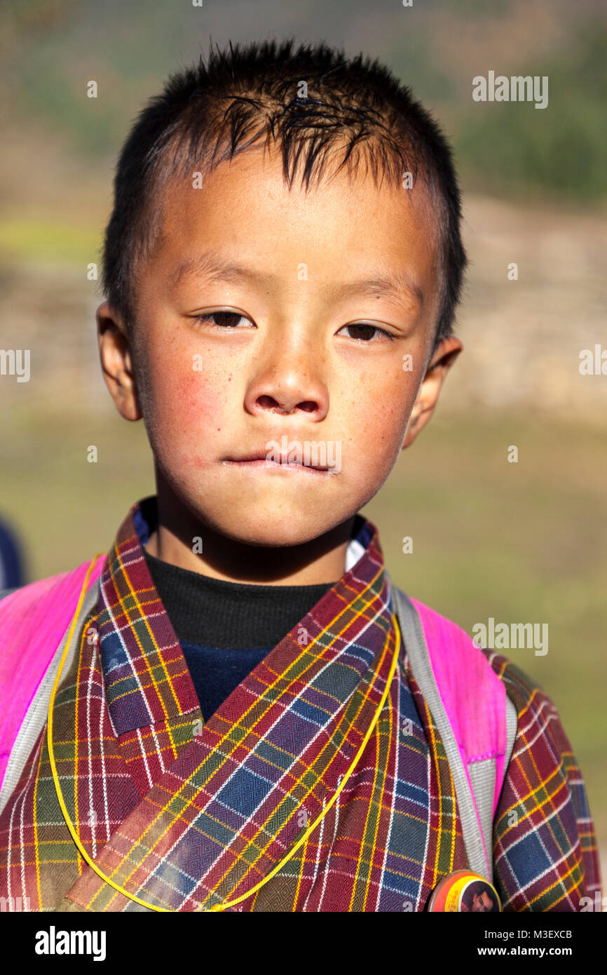 Le Bhoutan, Phobjikha. Jeune garçon vêtu du costume traditionnel Gho, Kikorthang Village. Banque D'Images