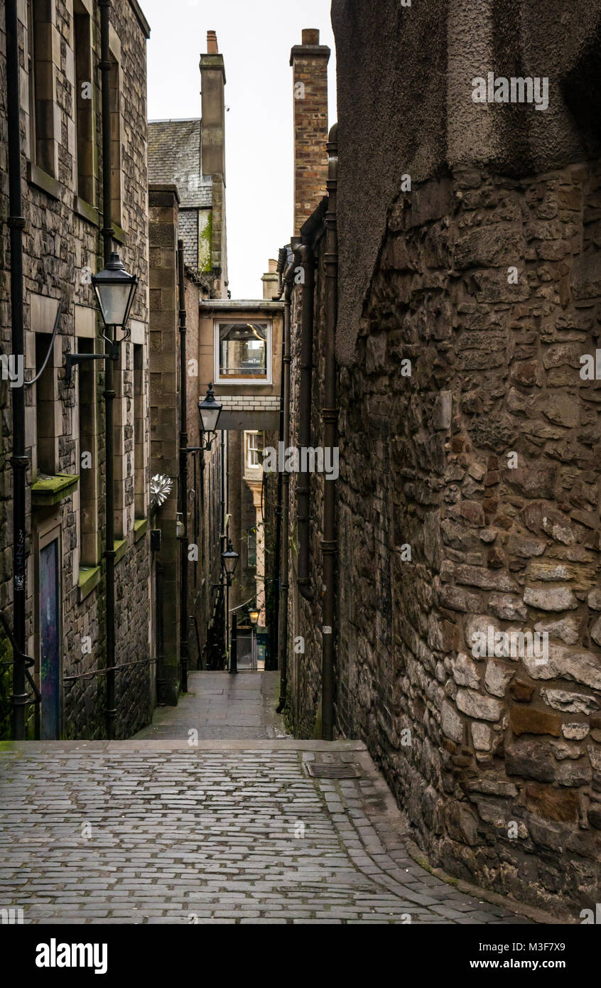 Vue vers le bas près d'ancrage, alley off Royal Mile, High Street, Édimbourg, Écosse, Royaume-Uni, avec des lumières de rue Victorien et chaussées pavées Banque D'Images