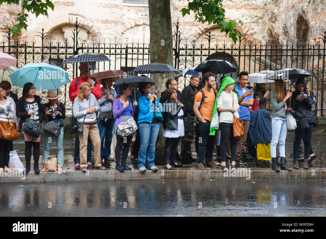 Des personnes non identifiées, l'attente sous la pluie pour la gay pride à passer par au Boulevard Saint-Michel, Paris, France. Banque D'Images