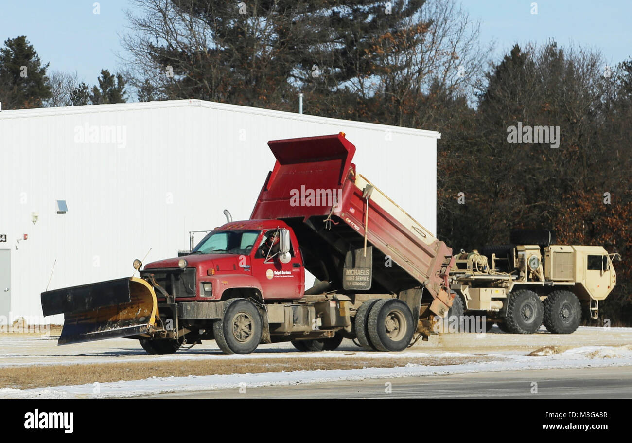 Un opérateur de l'équipement avec le Fort McCoy entrepreneur en déneigement, Kaiyuh Services LLC d'Anchorage, Alaska, les lieux du sable sur une surface glacée, le 30 janvier 2018, à Fort McCoy, au Wisconsin (É.-U. Army Banque D'Images