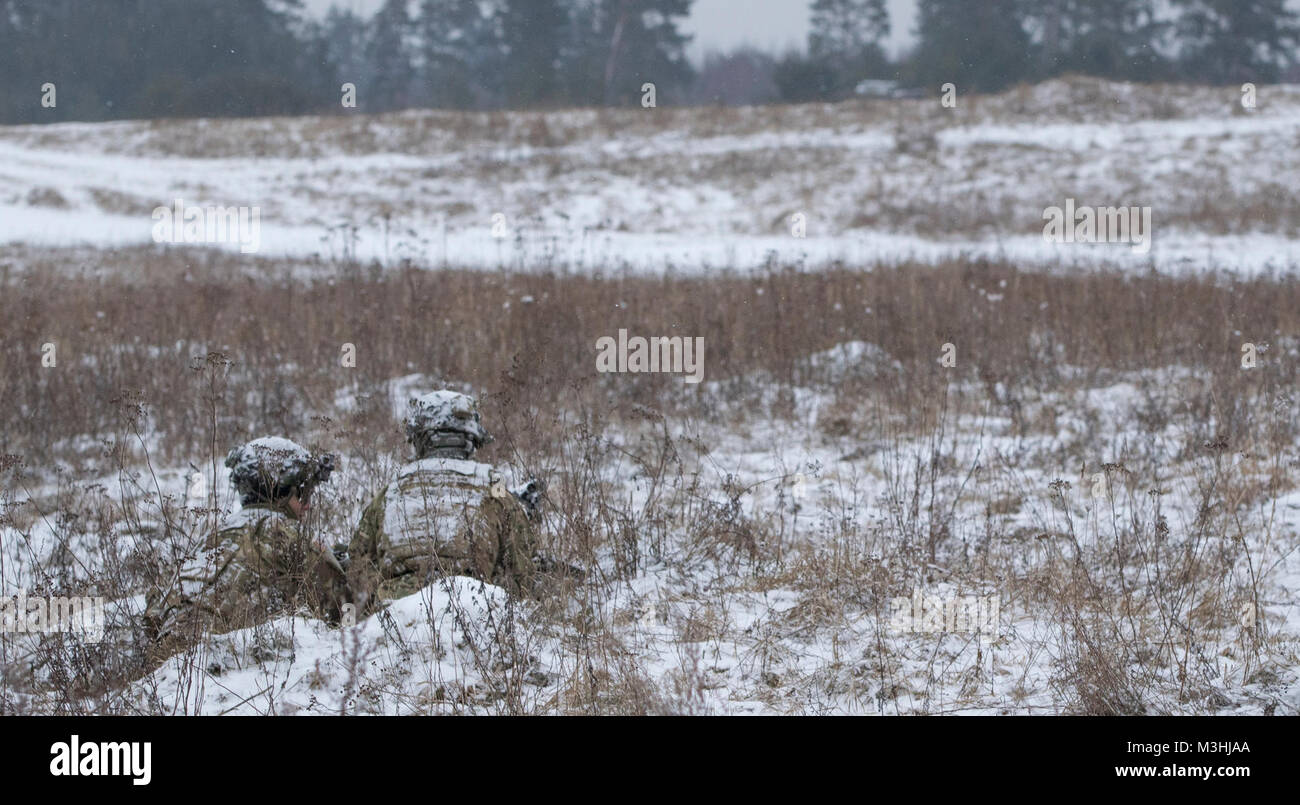 Des soldats américains affectés à la foudre Troop, 3e Escadron, 2e régiment de cavalerie, tirez sur la sécurité pendant l'exercice de poste de commandement près de la Belette Bemowo Piskie Domaine de formation, Pologne, le 6 février 2018. Ces soldats sont une partie de l'unique groupe de combat, multinationale, composée d'Américains, Britanniques, croate et soldats roumains servir avec la 15e Brigade mécanisée polonaise comme une force de dissuasion dans le nord-est de la Pologne à l'appui de l'OTAN vers l'amélioration de la présence. (U.S. Army Banque D'Images