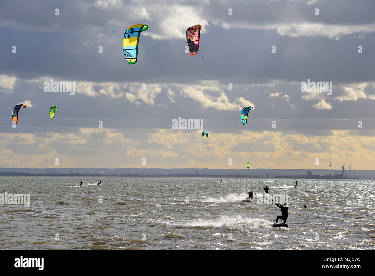 Les surfeurs de cerf-volant ont pris l'estuaire de la Tamise au large de Thorpe Bay, Southend on Sea, dans des vents forts mais froids avec l'île industrielle de Shepey dans le Kent Banque D'Images