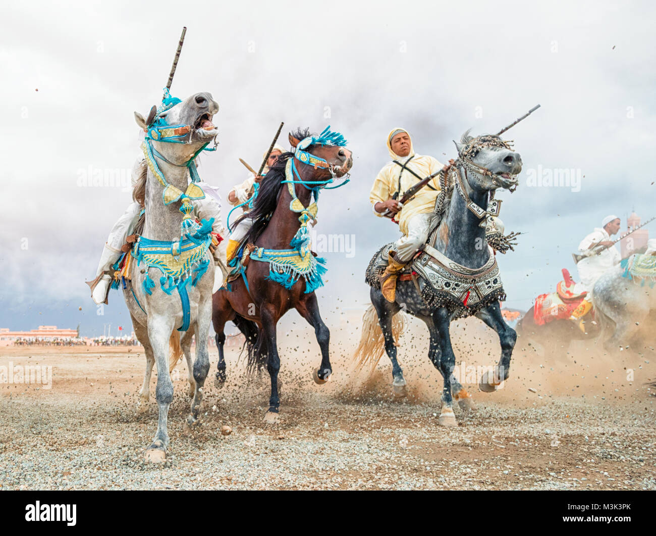 Chevaux et cavaliers le chargement avec les chevaux et le tir des fusils de guerre reproduisant des scènes d'attaque de Tbourida Mzoudia Maroc Banque D'Images