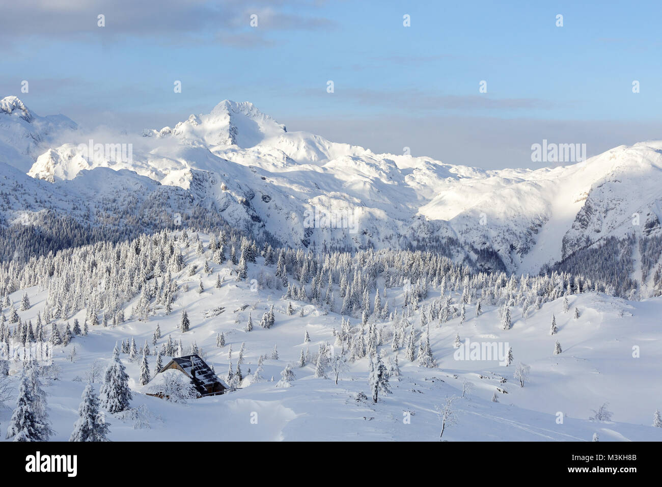 Vue panoramique de cabines en bois couvert de neige et les montagnes atforest Velika planina, la Slovénie. Banque D'Images