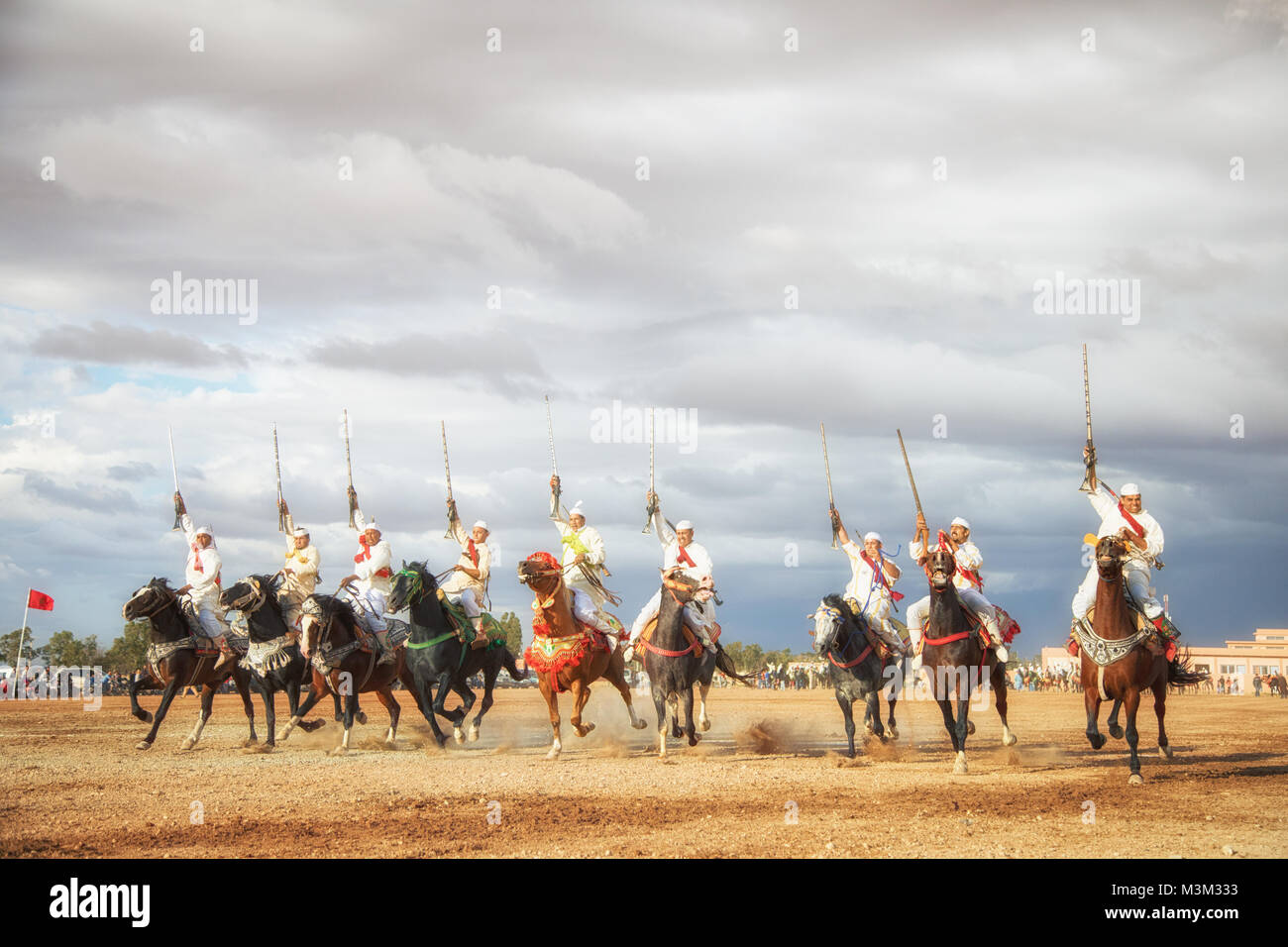Chevaux et cavaliers le chargement avec les chevaux et le tir des fusils de guerre reproduisant des scènes d'attaque de Tbourida Mzoudia Maroc Banque D'Images