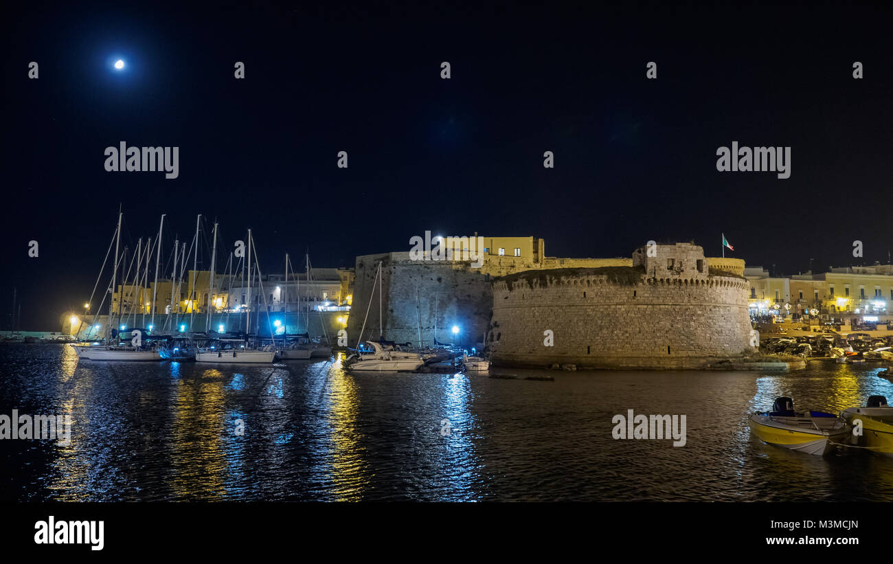 Gallipoli (Pouilles - Italie), août 2017. Vue de la nuit de l'Angevine-Aragonese Château et le vieux port. Le format paysage. Banque D'Images