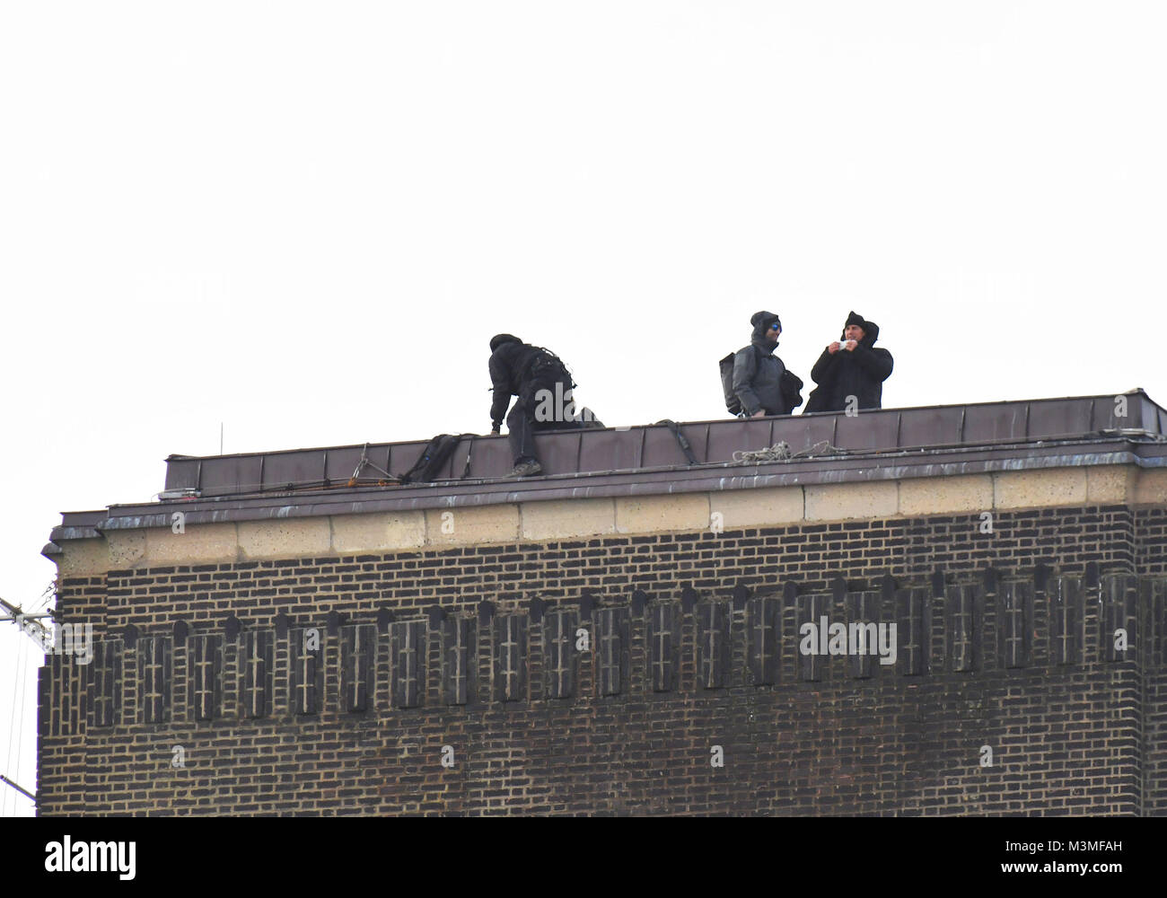 Tom Cruise (à droite) s'apprête à courir vers un hélicoptère sur la cheminée haut de la Tate Modern Gallery de Londres, lors du tournage d'une scène de Mission Impossible 6. Banque D'Images