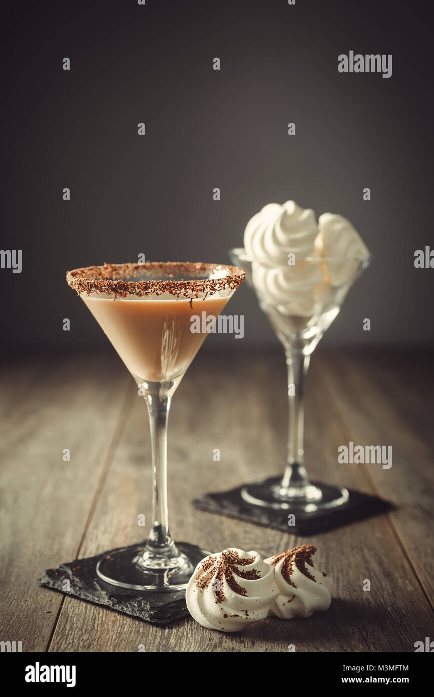 Boisson à la crème irlandaise en verre avec rim enrobées de chocolat et un verre de mini meringues à l'arrière-plan Banque D'Images
