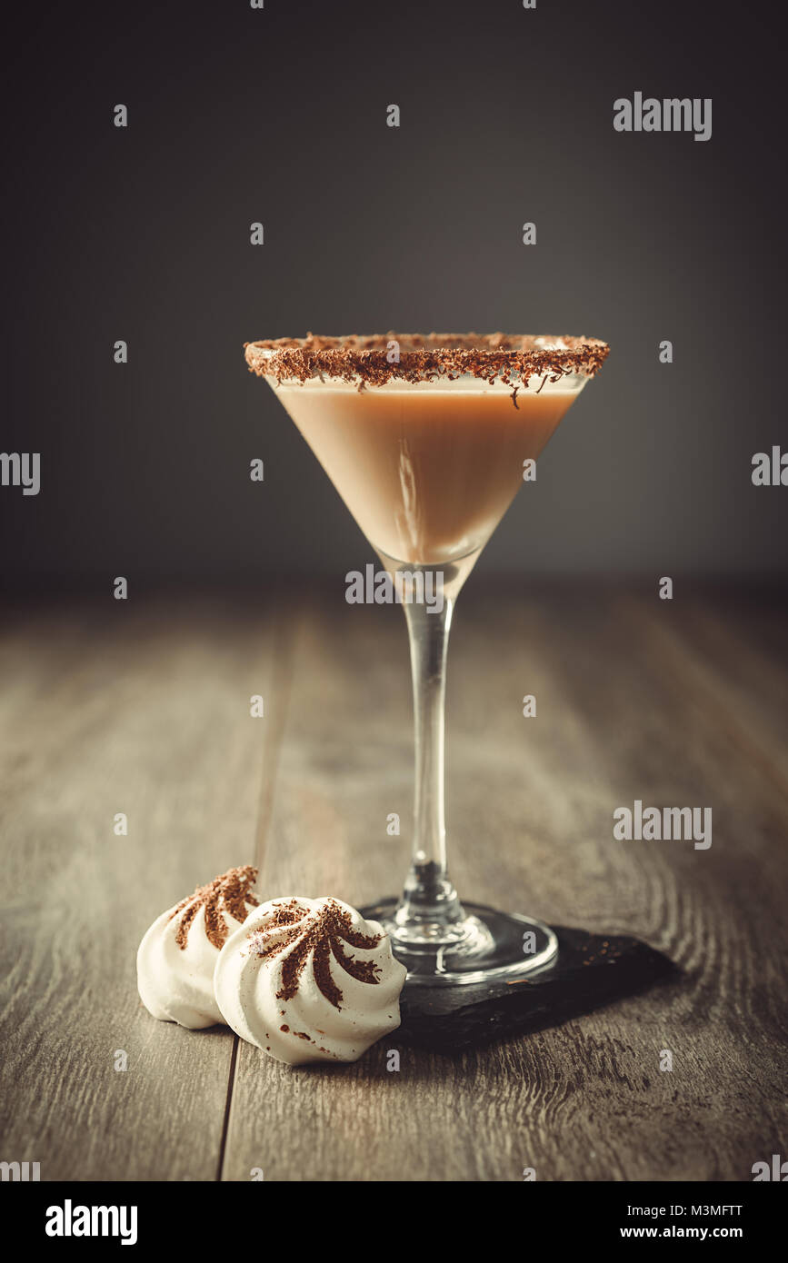 Verre de boisson à la crème irlandaise boire dans un verre avec du chocolat avec jante mini meringues sur ardoise coaster Banque D'Images