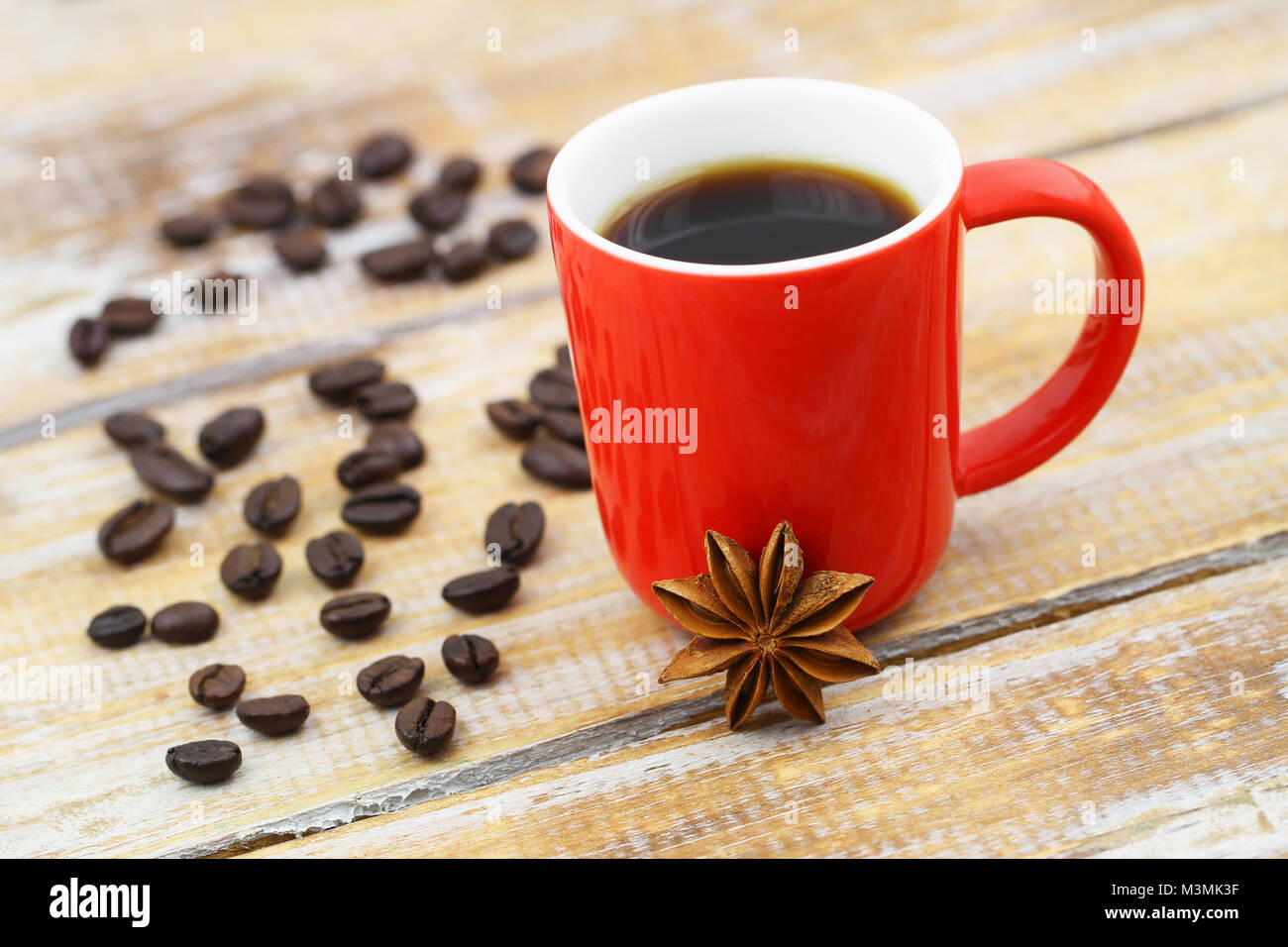 L'anis étoilé appuyé contre la grande tasse de café sur la surface en bois rustique Banque D'Images