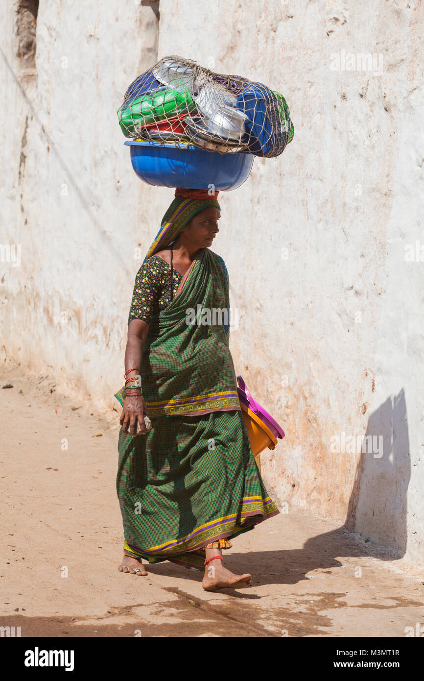 L'Inde, Karnataka, Badami, femme portant un panier avec des pots sur la tête. Banque D'Images