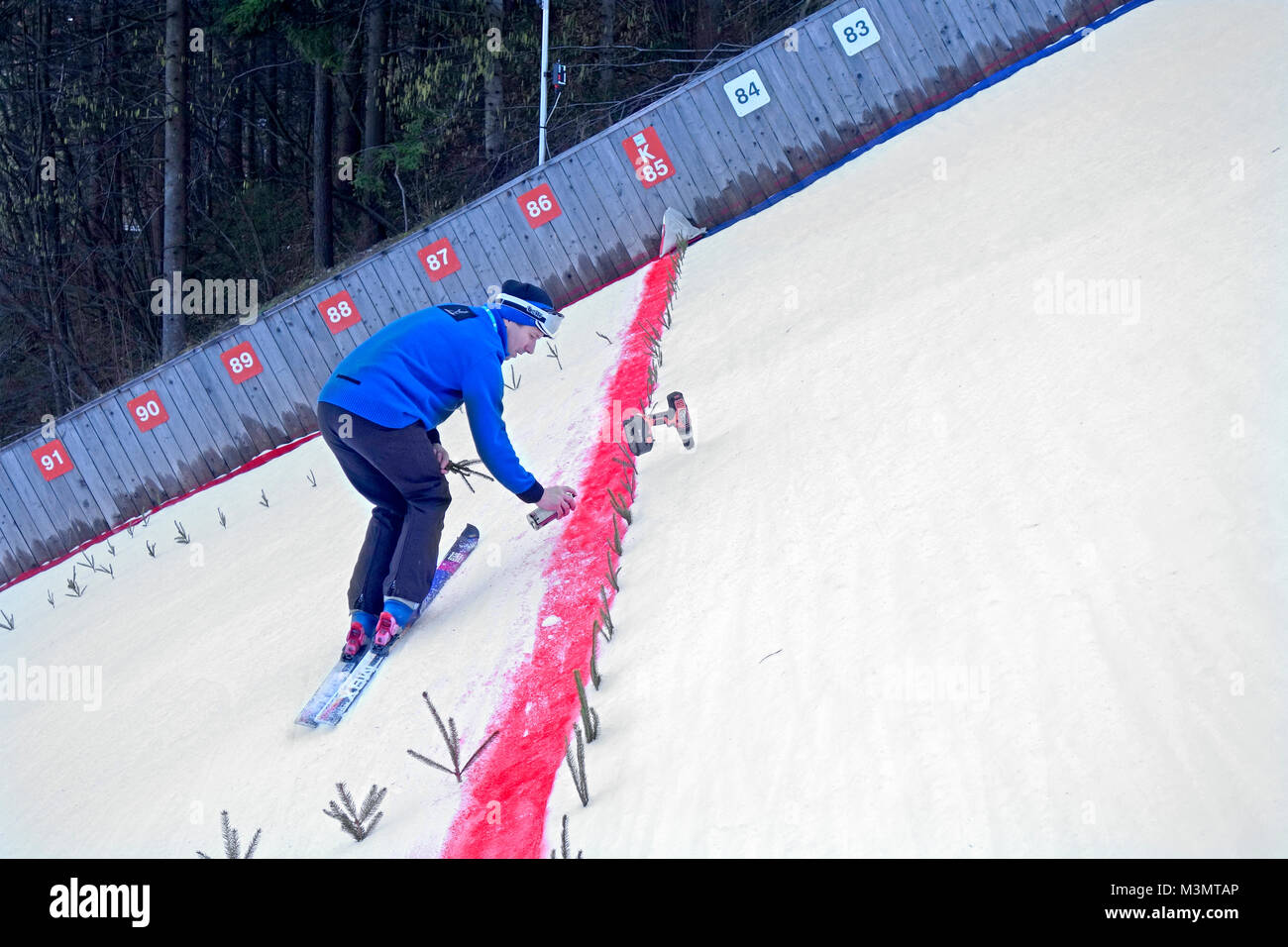 Le saut à ski hill. Un homme est marquant la ligne rouge de 'point critique' ou 'point' où la construction Hill est la plus forte et où les concurrents sont e Banque D'Images