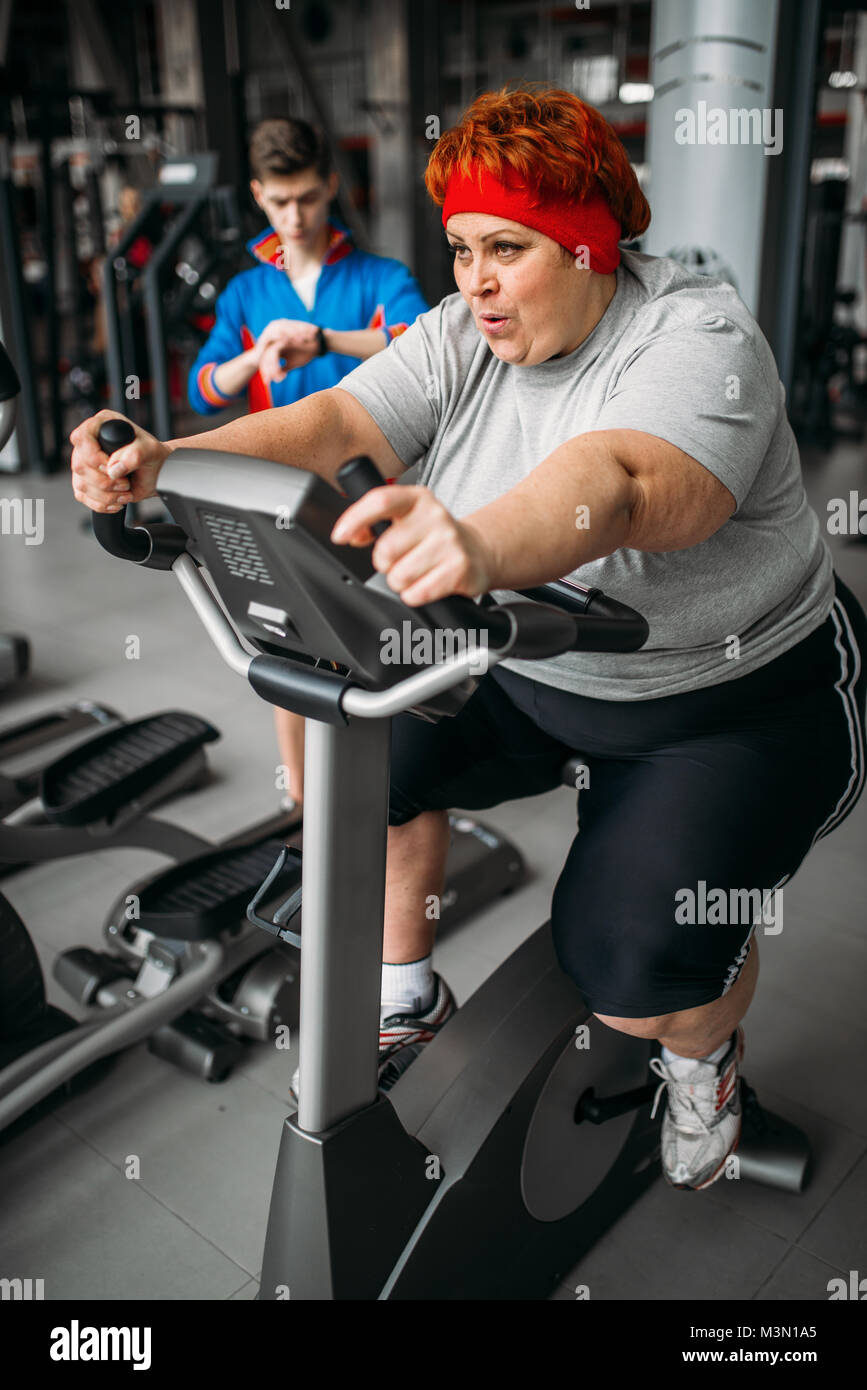 L'excès de femme, d'entraînement sur un vélo d'exercice dans la salle de sport. Calories de