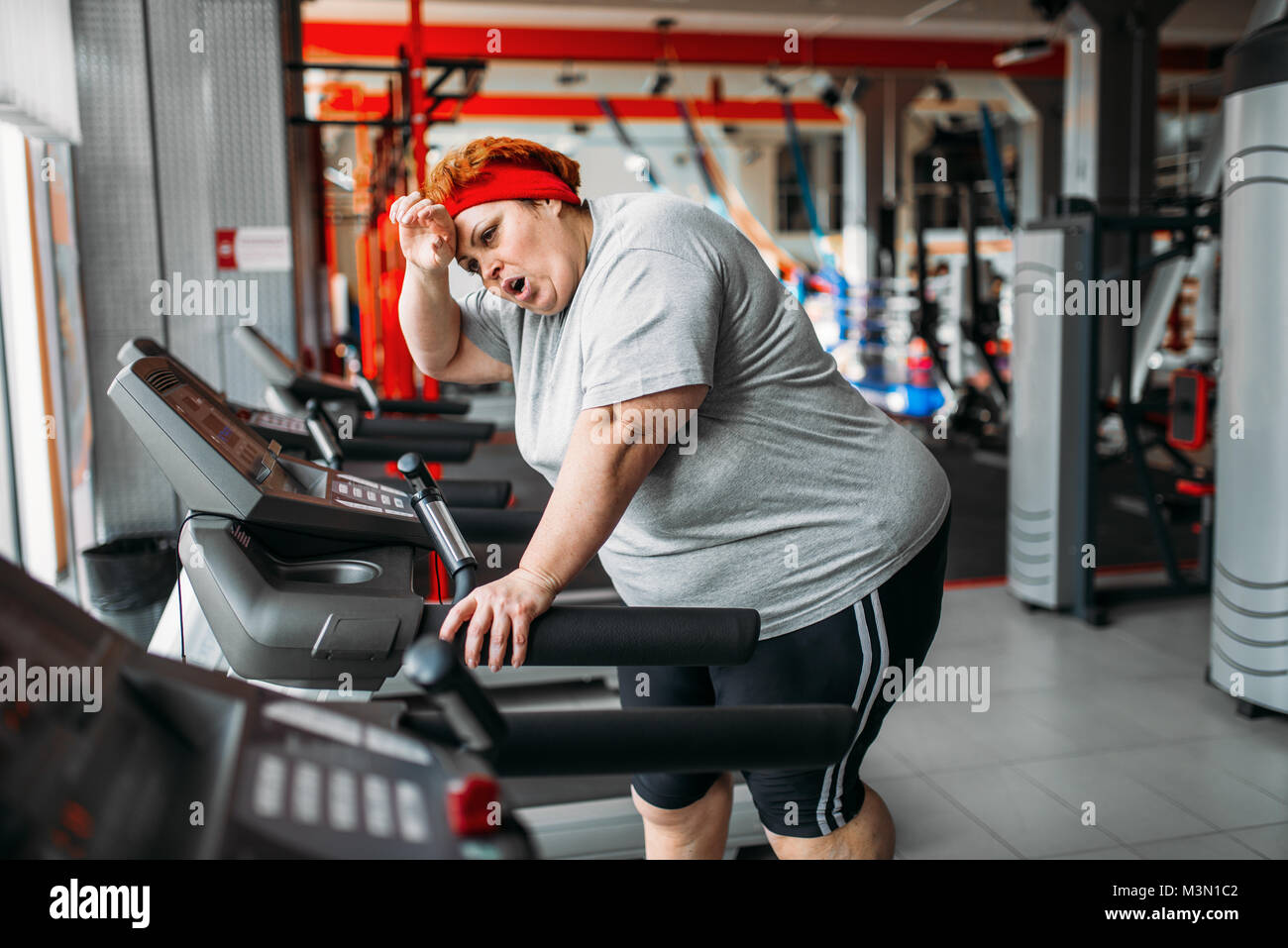 L'excès de femme fatiguée d'exécution sur un tapis roulant dans une salle  de sport. Calories de brûlure, de femmes obèses personne dans le sport club  Photo Stock - Alamy