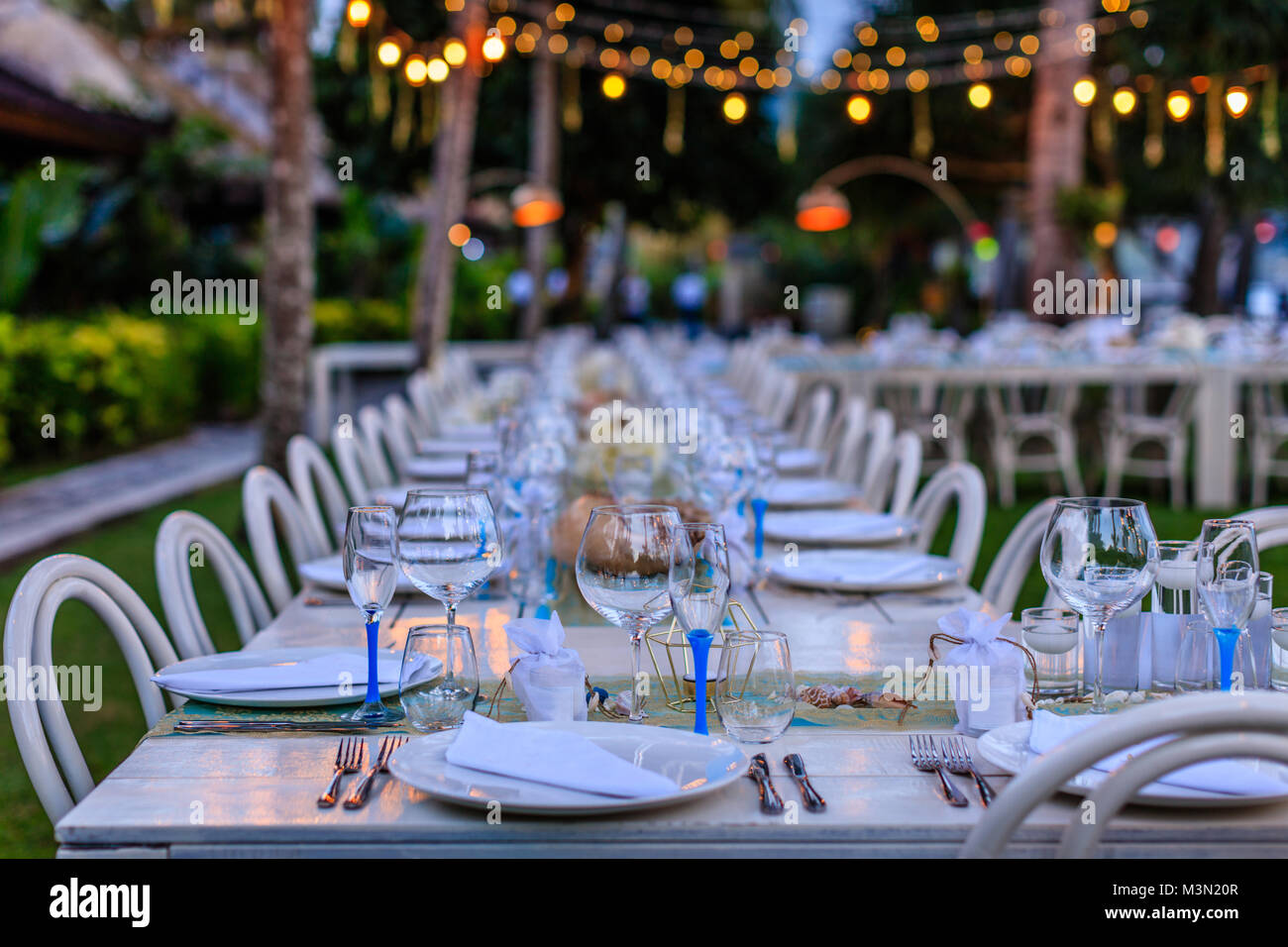 Set Table pour un livre blanc et bleu aqua beach dîner de mariage décorés de coquillages, lumière du soir. Banque D'Images