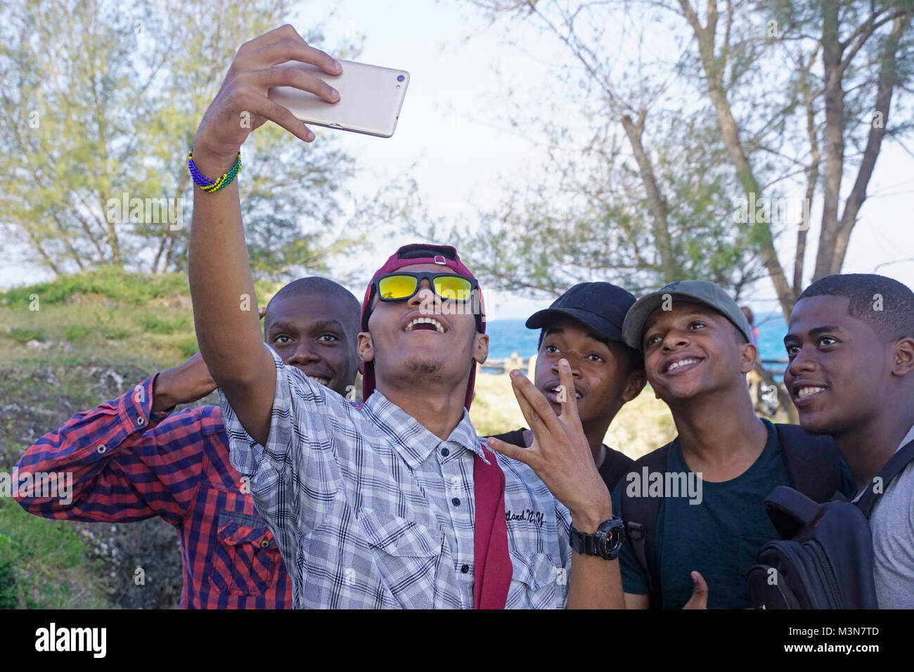 Les jeunes hommes de prendre une photo avec un selfies dans un téléphone cellulaire à Zanzibar. Banque D'Images