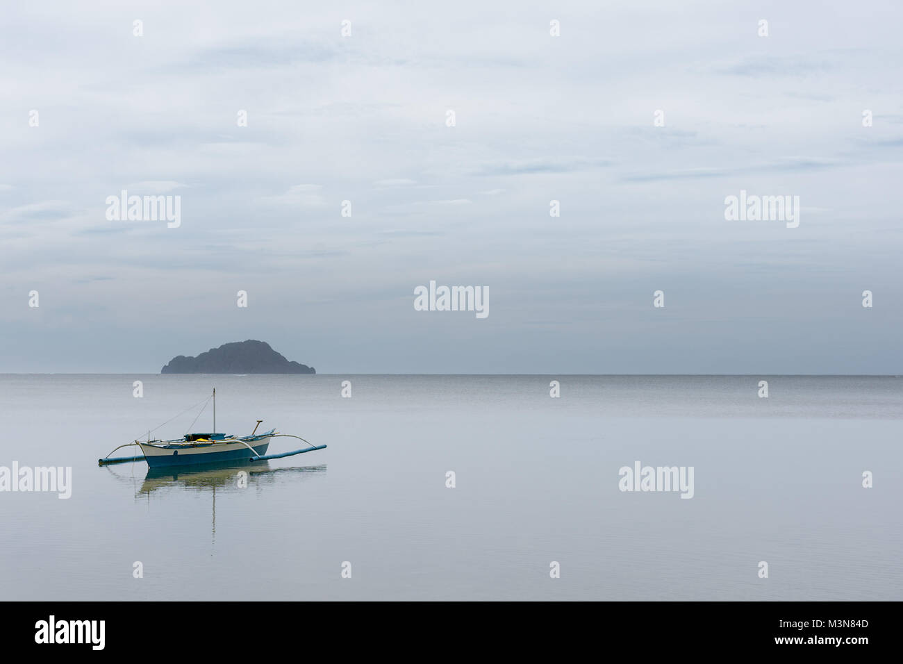 Bateaux de pêcheurs philippins avec stabilisateurs traditionnelle flottent encore ancrée dans une mer calme de Coron Bay, Palawan, Philippines. Banque D'Images