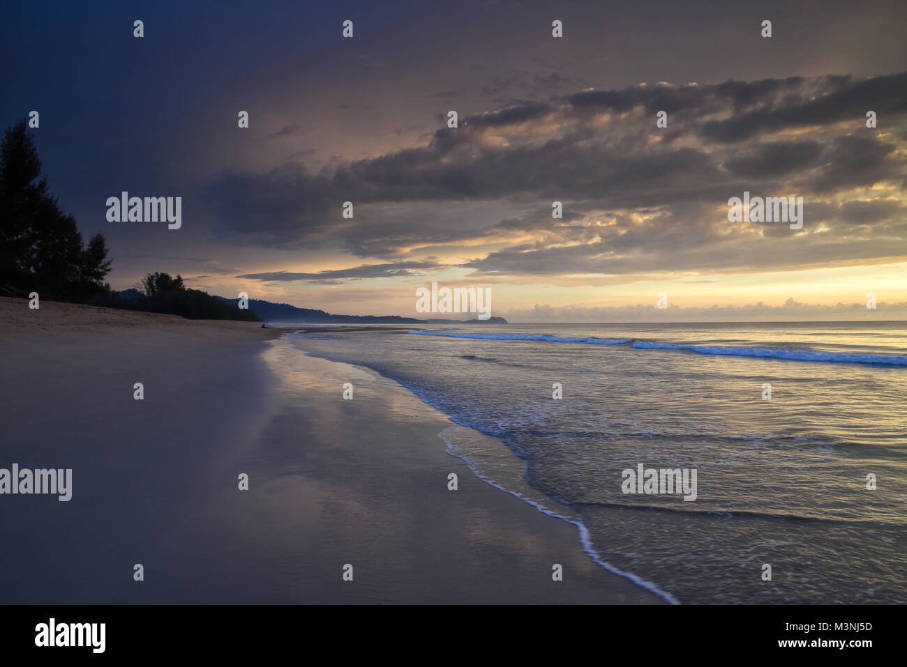 Belles couleurs pastel le long de la plage en Thaïlande comme le soleil se couche avec ciel nuageux et réflexions Banque D'Images