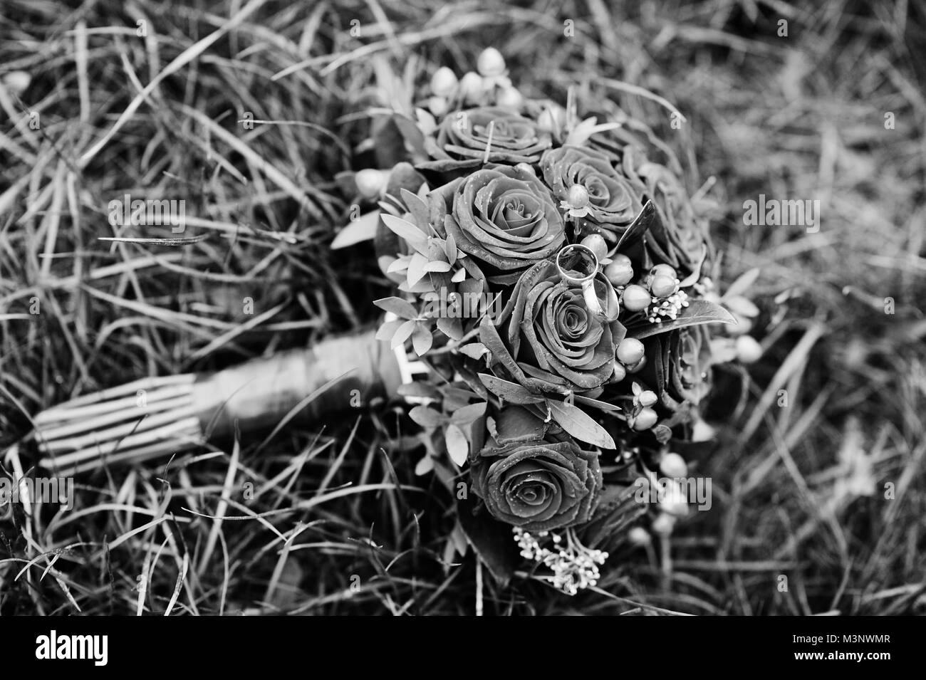 Photo en gros plan d'un mariage bouquet composé de roses rouges et de baies. Photo en noir et blanc. Banque D'Images