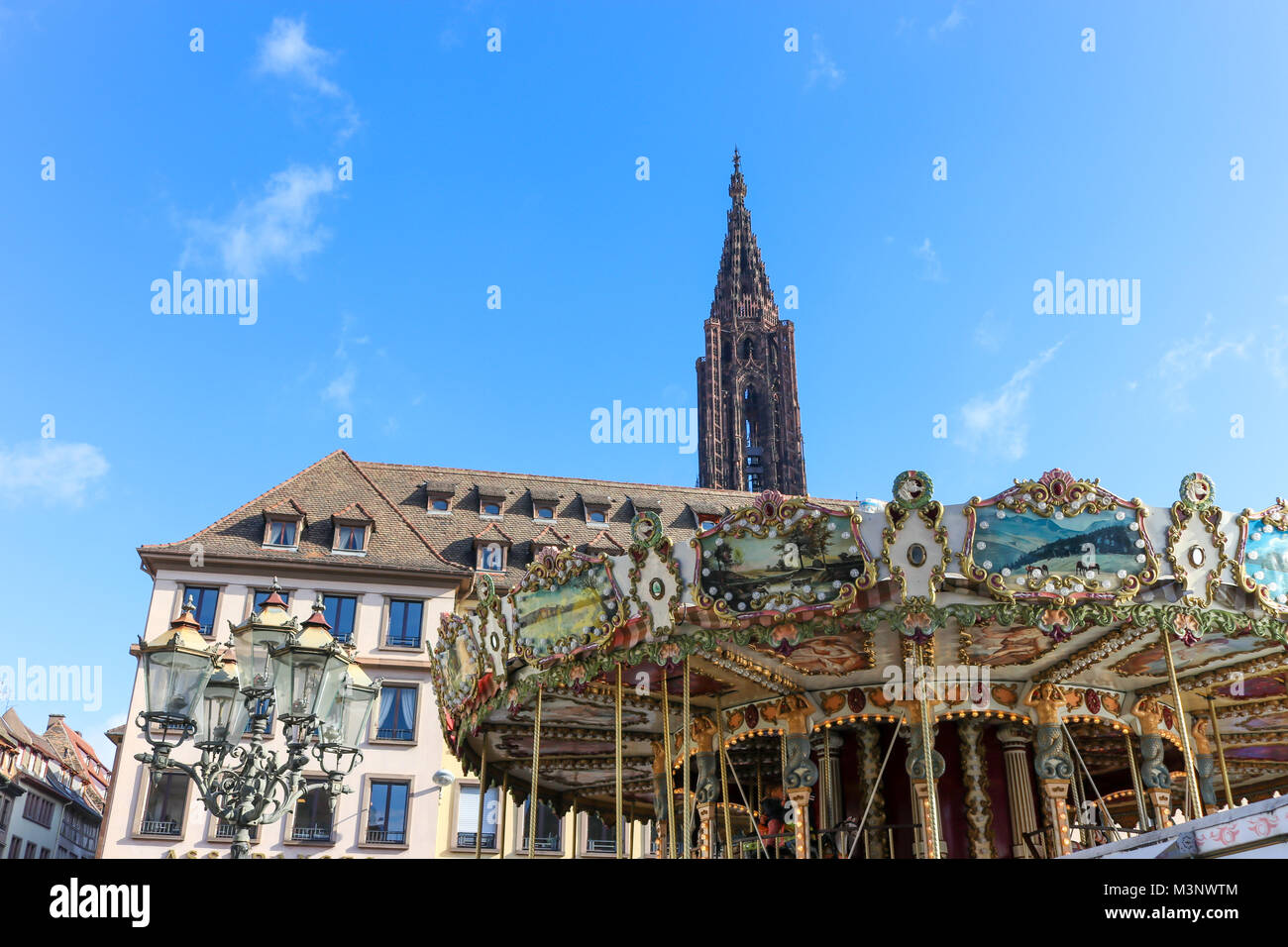 Carousel à place Gutenberg à Strasbourg, France. La Cathédrale peut être vu dans l'arrière-plan sur le fond bleu ciel d'été. Banque D'Images