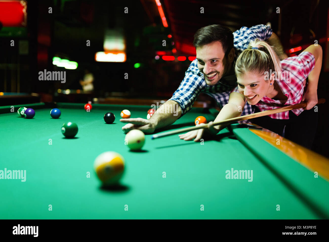 Jeune couple playing snooker ensemble dans bar Banque D'Images