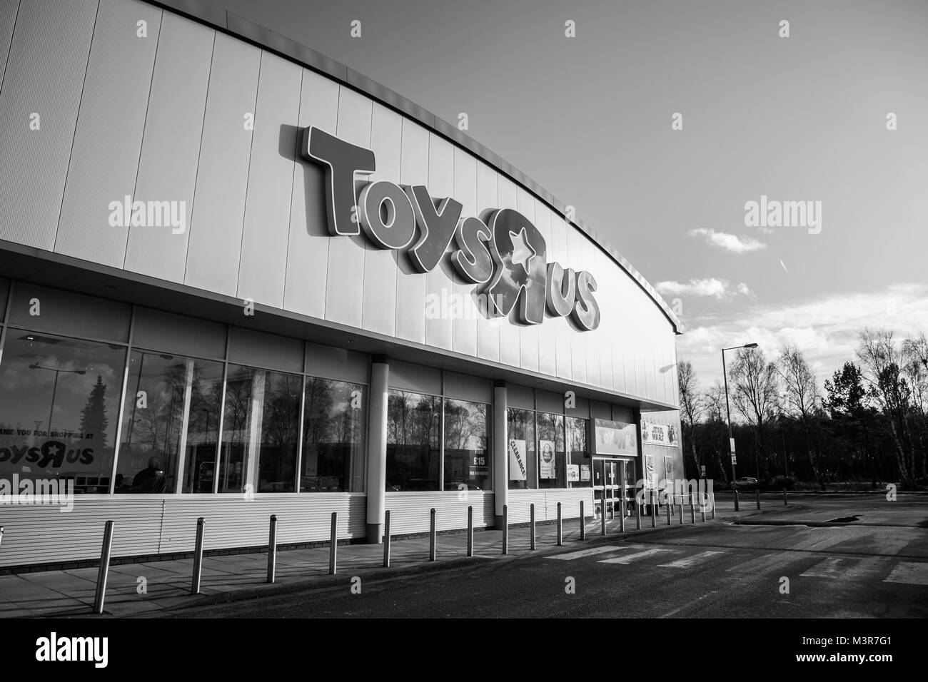 Toys R Us store front et parking vide jours après qu'il a annoncé qu'elle allait fermer 16 de ses magasins au Royaume-Uni. 12 février 2018. Noir et blanc. Banque D'Images