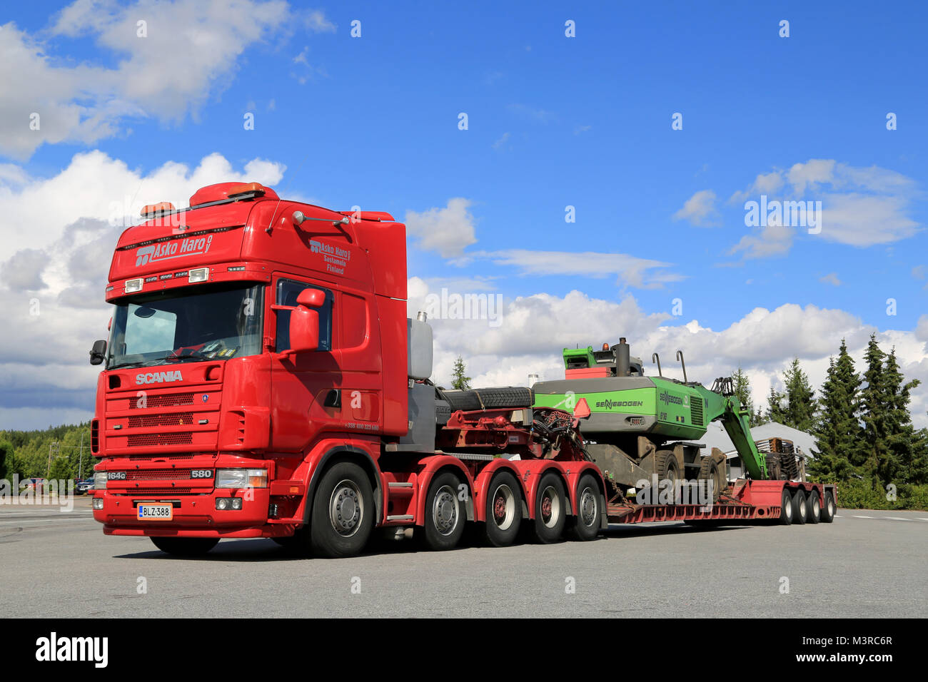 FORSSA, FINLANDE - le 16 août 2014 : Scania 164G 480 Sennebogen 818 transport par camion sur la machine de manutention remorque plate-forme goutte. Sennebogen 818 est utiliser Banque D'Images