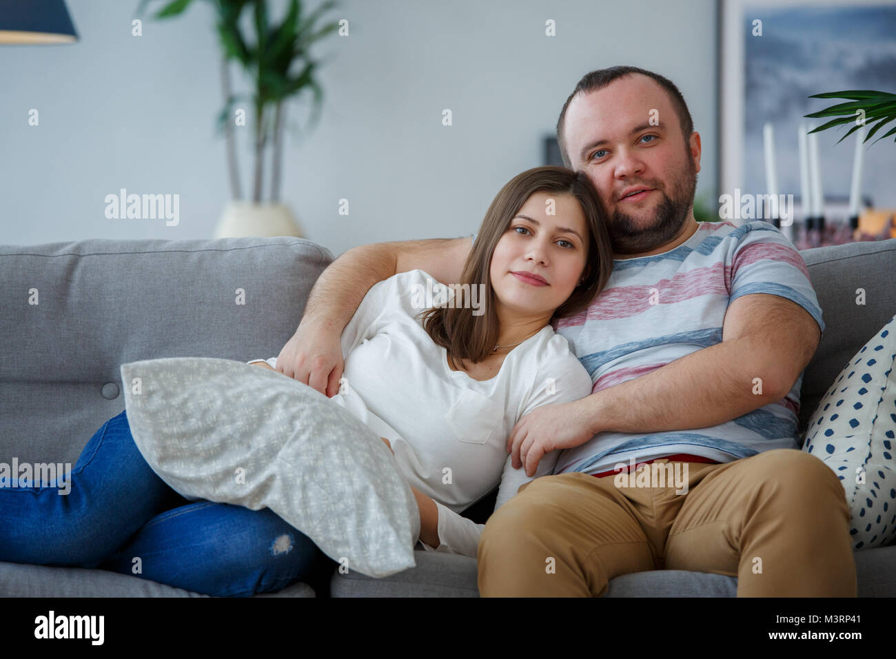 Image d'amoureux câlins sur canapé gris Photo Stock - Alamy