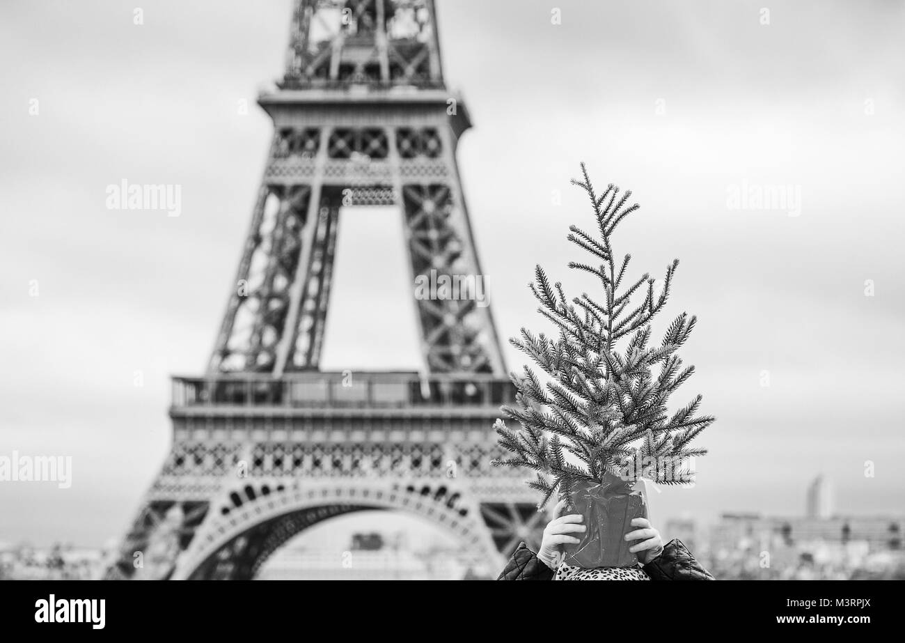 La saison des festivals à Paris. Gros plan sur la mode enfant heureux dans l'avant de la tour Eiffel à Paris, France holding Christmas Tree on head Banque D'Images