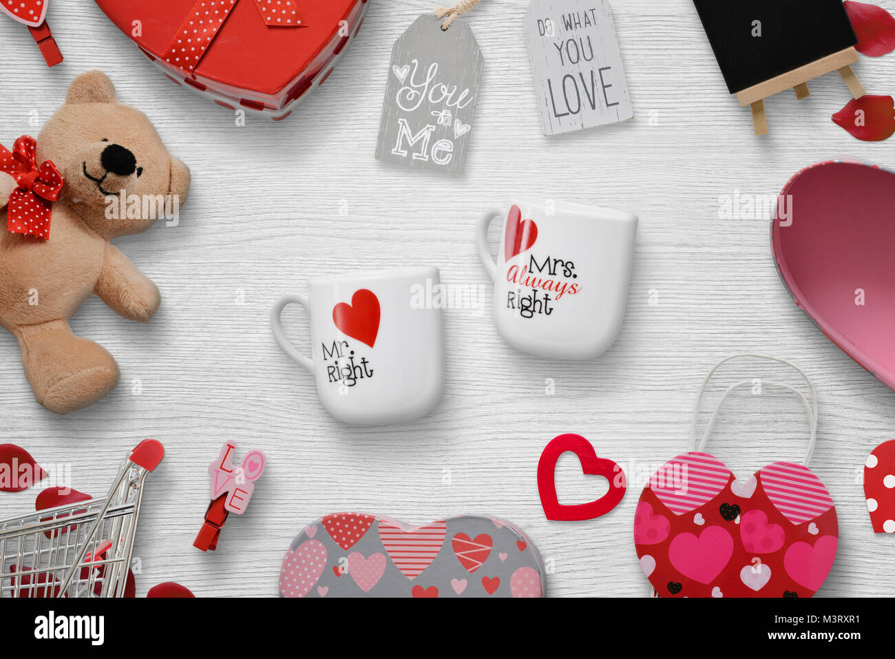 Saint Valentin cadeaux sur un fond de bois blanc. Des cadeaux, des tasses, des clips, des ours, des inscriptions. Vue d'en haut. Banque D'Images