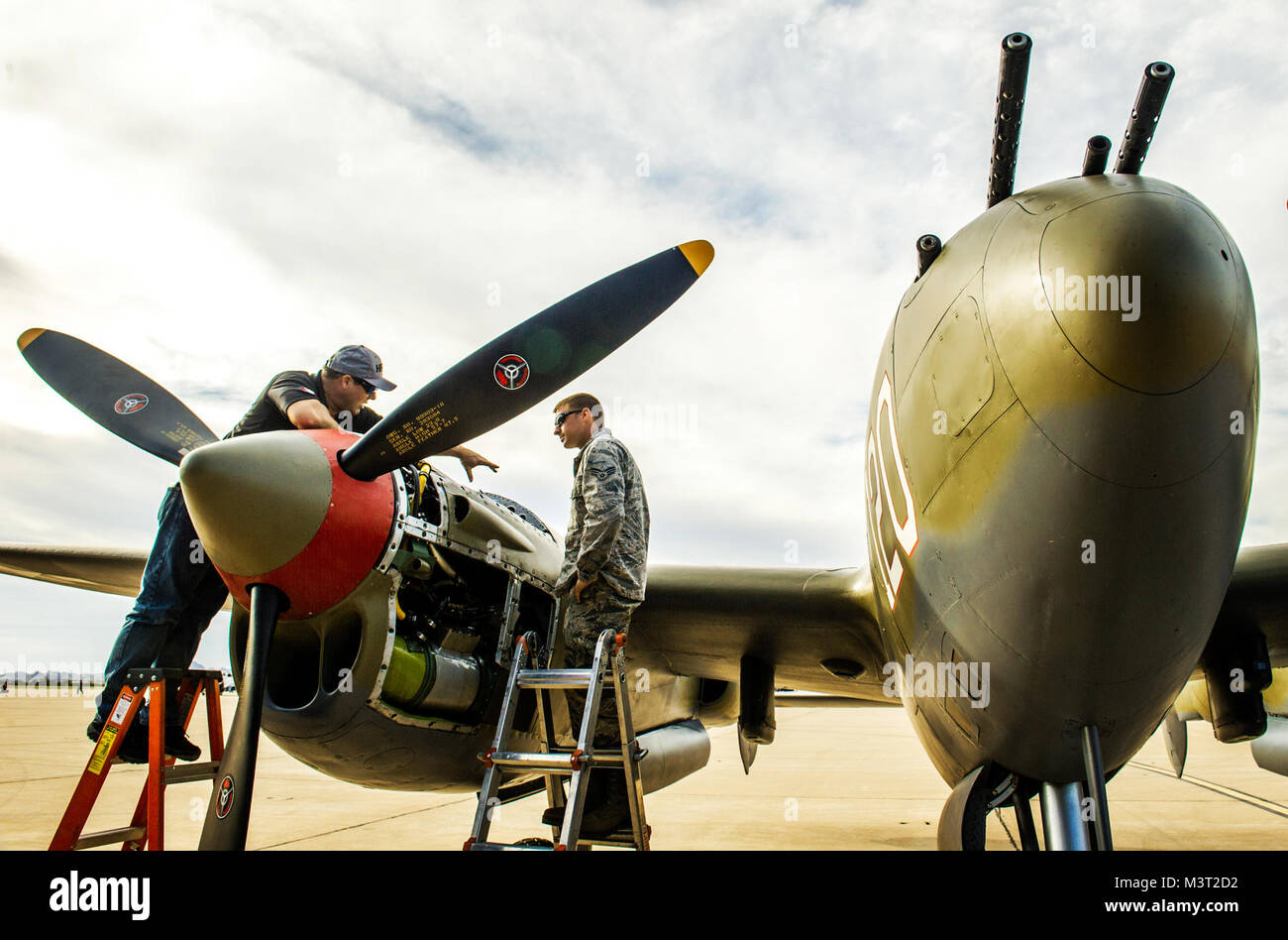 Anthony Naugle Senior Airman, droit, l'A-10 le chef d'équipe avec le 357e Escadron de chasse, 355e Fighter Group basé à la base aérienne Davis-Monthan AFB, Tucson (Arizona), obtient une leçon dans le maintien de l'un des deux 1 000 kW (746 hp), turbo-compresseur, 12 cylindres moteurs Allison V-1710 sur un P-38 'Lightning' de Doug Abshier après leur journée de pratique des vols à la formation de vol du patrimoine, Mar 5, 2016. (U.S. Air Force photo par J.M. Eddins Jr.) 160305-F-LW859-021 par AirmanMagazine Banque D'Images