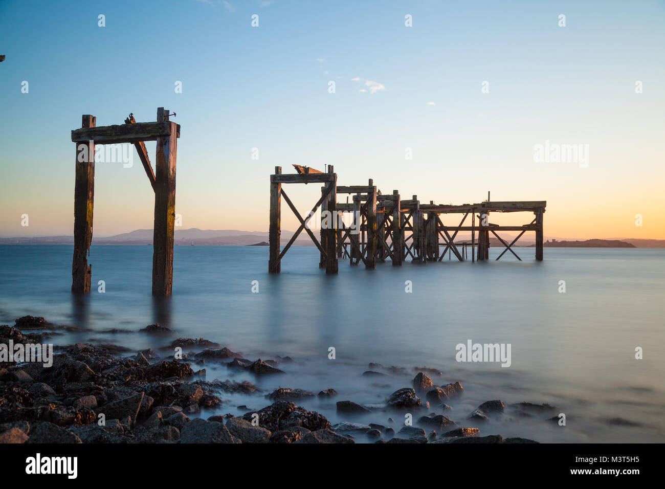 L'ancienne jetée en bois à Hawkcraig Point au coucher du soleil, près de Fife Aberdour en Écosse. Banque D'Images