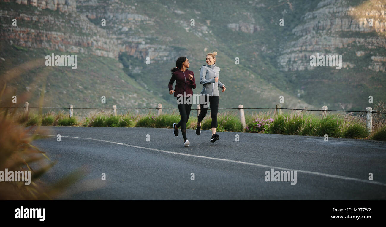 Deux femmes partent courir tôt le matin. coureurs de fitness en combinaisons de course sur route. Banque D'Images