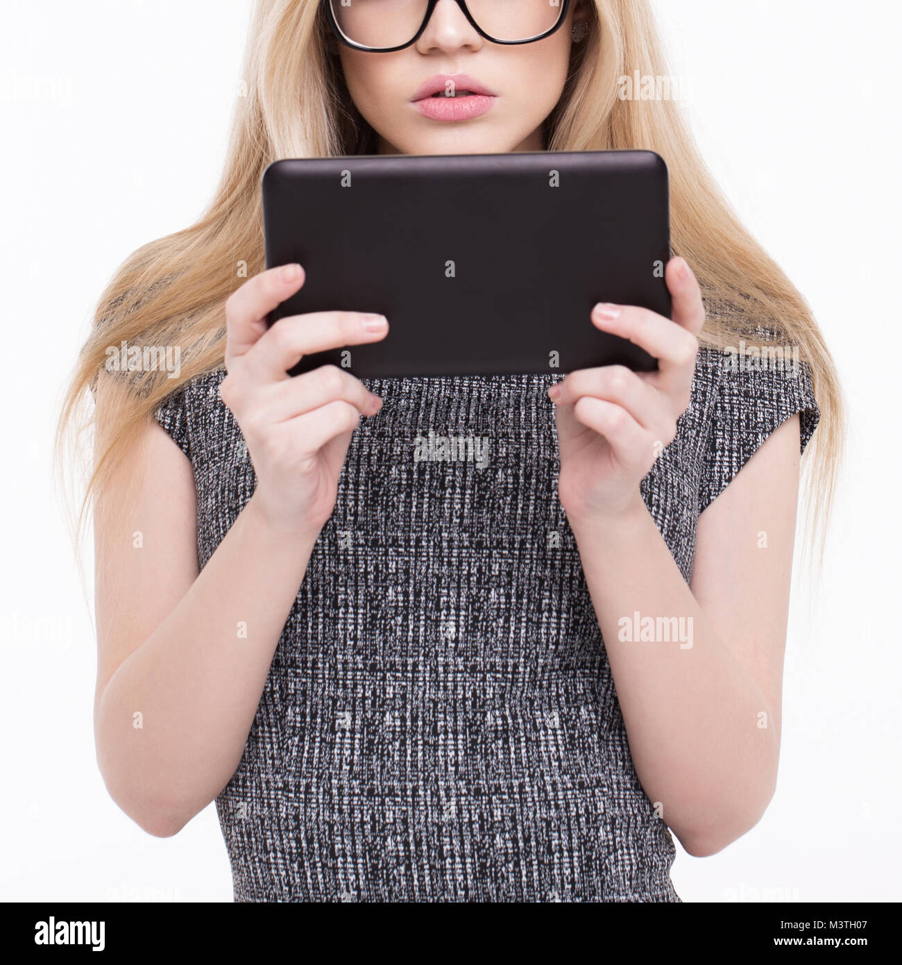 Young blonde woman reading on tablet closeup Banque D'Images