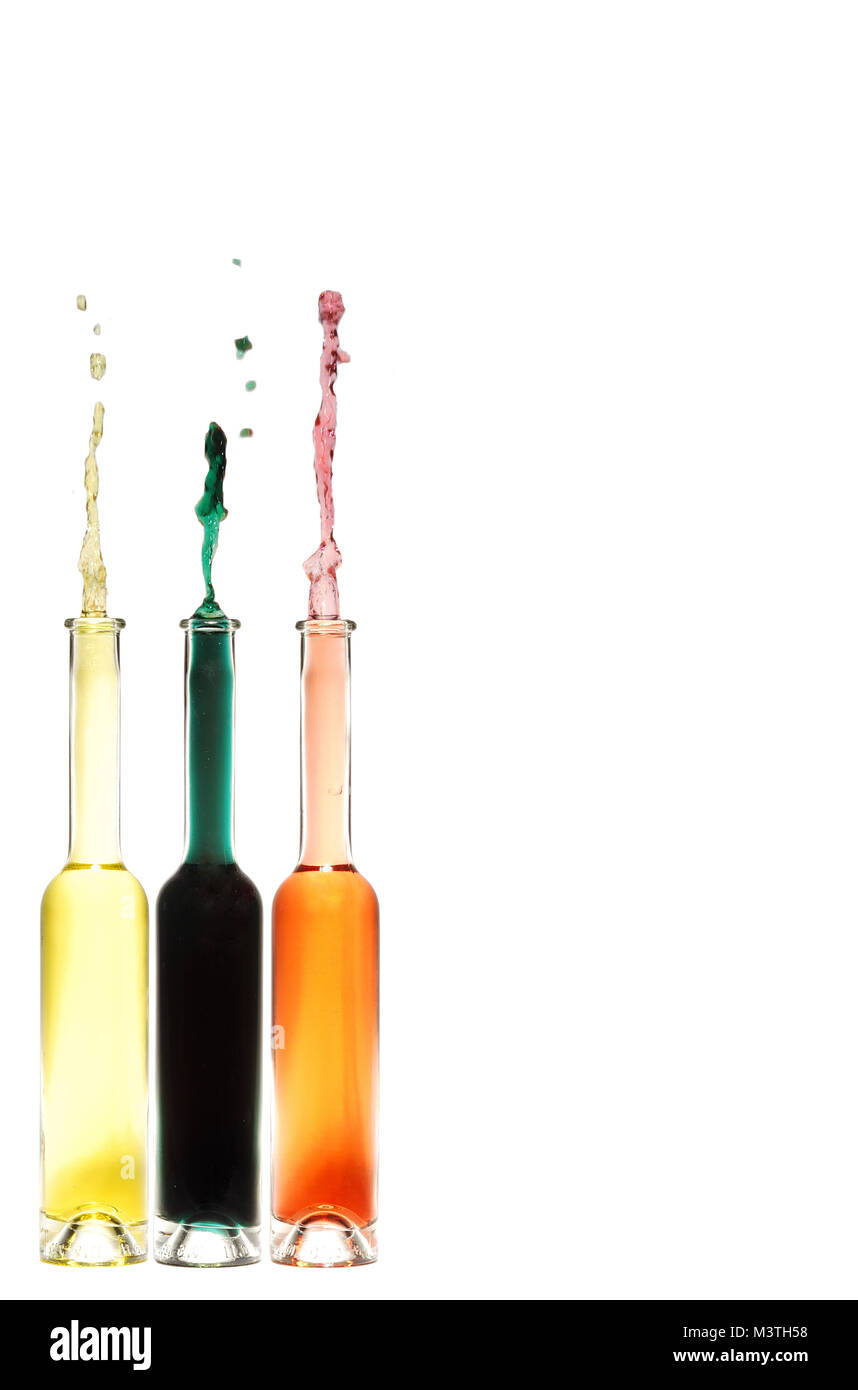 Trois bouteilles avec liquide coloré sur le sol et montage photo jaillissante gauche Banque D'Images