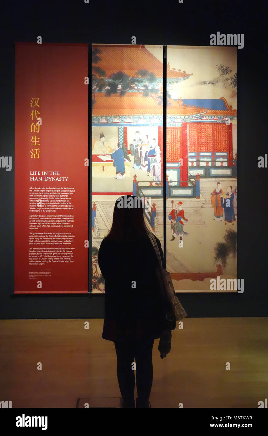 Jeune Femme regardant une affiche dans le premier empereur de Chine et les guerriers de terre cuite Exposition sur l'affichage à l'World Museum, Liverpool, en Angleterre. Banque D'Images