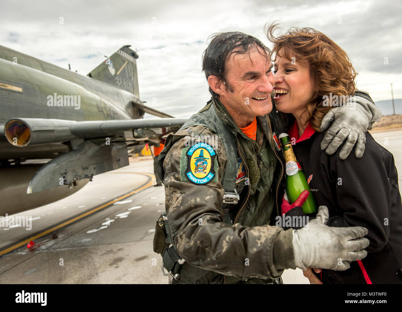 QF-4E civil Contrôleur/Pilote Le Lieutenant-colonel (retraité) Jim ÒWAMÓ Harkins, embrasse son épouse Annette, après avoir été couverts de champagne au moment de sortir de l'habitacle de son McDonnell Douglas F-4 Phantom II pour la dernière fois peu après le dernier vol militaire de l'étagé appareil à Holloman AFB, N.M., 21 décembre 2016. La dernière variante de la Phantom II était le QF-4 objectifs aériens sans pilote utilisé par le 82e Escadron de cibles aériennes 1 Détachement à Holloman AFB. La cérémonie a été de vol dans un cockpit dernier Harkins pour l'Armée de l'air ; il va maintenant servir de contrôleur sol pour le QF-4's le remplacement, le QF-16. L Banque D'Images