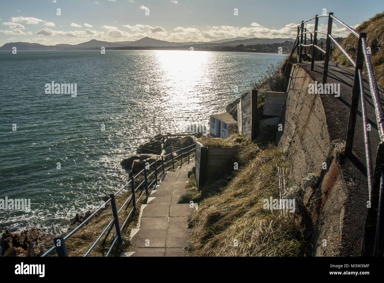 Étapes vers le bas pour Vico lieu de baignade ; associée à une vue de la baie de Killiney. Banque D'Images