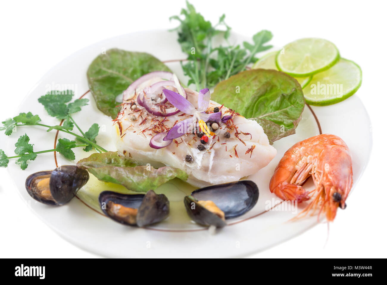 Les filets de morue, morue de l'Atlantique avec des fruits de mer mussells,crevettes,tilleul et de légumes, sur fond blanc Banque D'Images