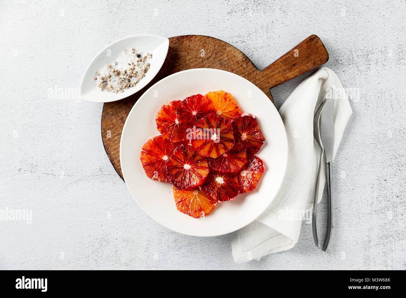 Les tranches d'orange rouge tranché sur une assiette. base en dessert ou salade. été style sur un tableau blanc en pierre Banque D'Images