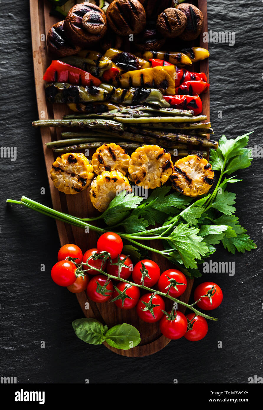 Légumes grillés sur un plateau en bois sur une ardoise noire. copie espace, frais généraux shot Banque D'Images