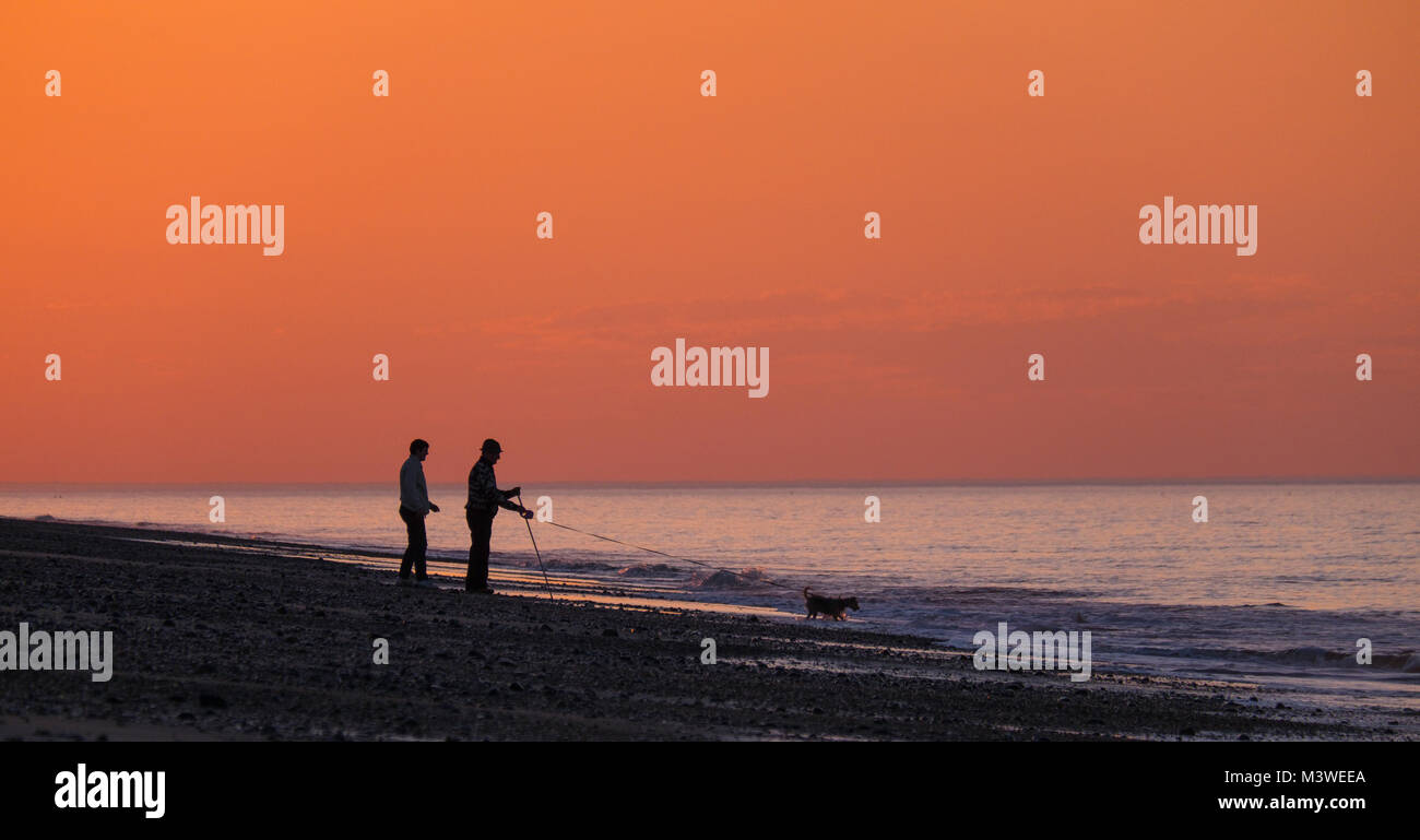 Trois amis sur la plage au coucher du soleil . Banque D'Images