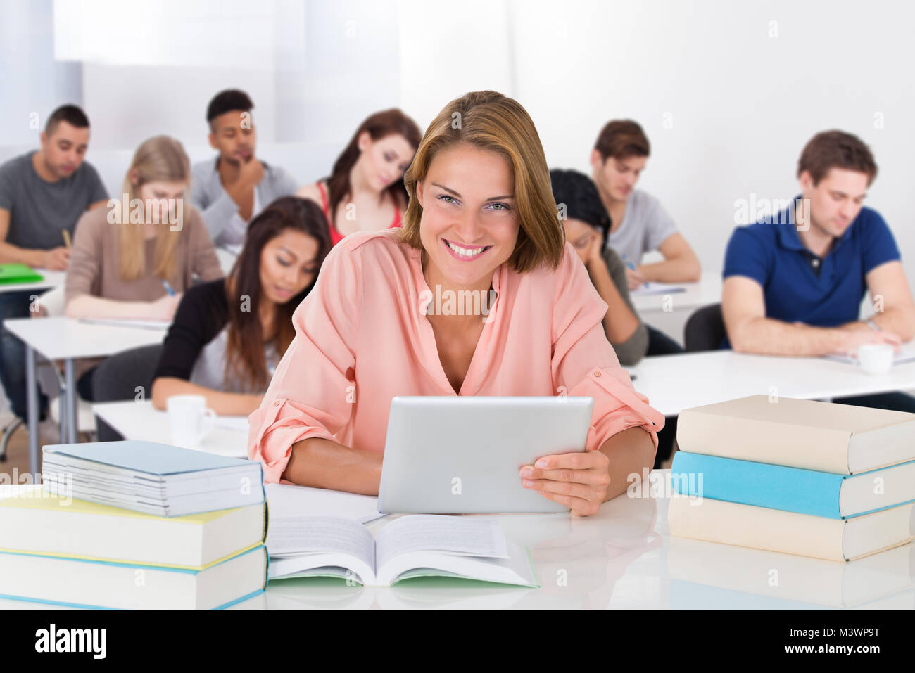 Portrait d'un jeune étudiant avec laptop Sitting in Classroom Banque D'Images